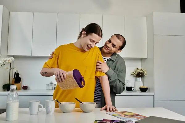 A gay couple shares a tender moment in their kitchen as they prepare breakfast together. — Stock Photo