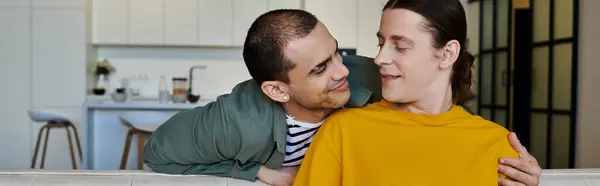 Una giovane coppia gay si siede su un divano nel loro appartamento moderno, godendosi reciprocamente compagnia. — Foto stock