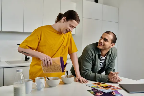 A young gay couple in casual attire enjoys breakfast together in a modern apartment. — Stock Photo