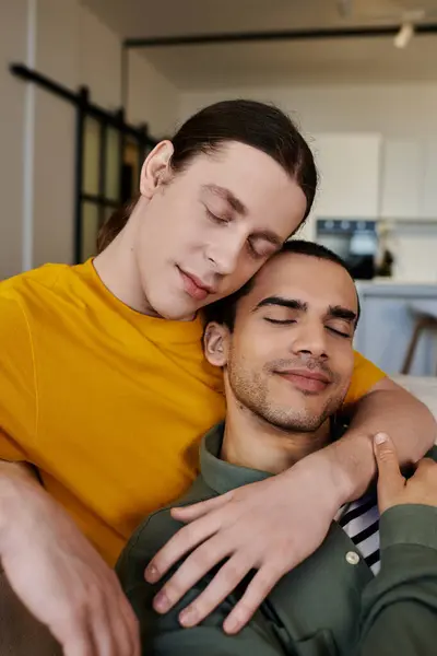 A young gay couple enjoys a quiet moment together in their modern apartment. — Stock Photo
