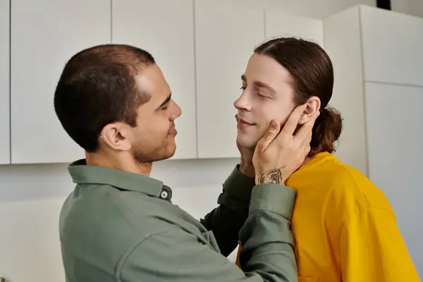 A young gay couple shares a tender moment in their modern apartment, their love and connection palpable in the air. — Stock Photo