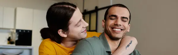 A young gay couple enjoys a quiet moment together in their modern apartment. — Stock Photo