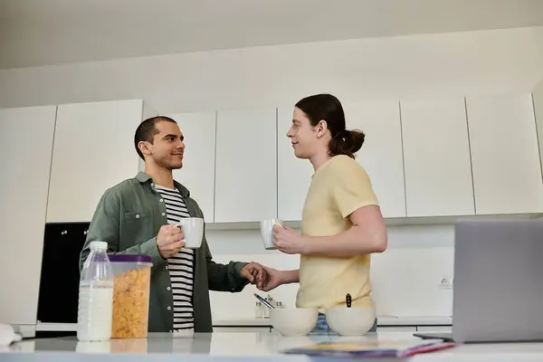 A young gay couple enjoys a casual morning together in their modern apartment, sipping coffee and chatting. — Stock Photo