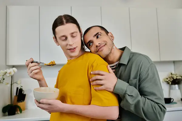 A young gay couple enjoys breakfast in their modern apartment, sharing a tender moment with a hug. — Stock Photo
