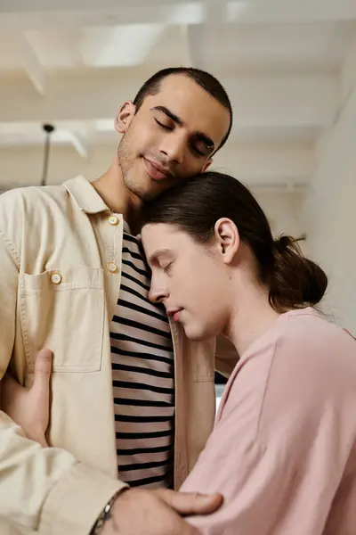 A young gay couple embraces in a modern apartment, enjoying a moment of intimacy and connection. — Stock Photo