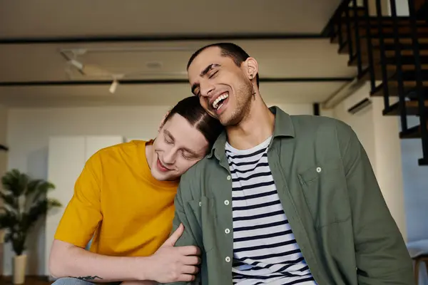 Ein junges schwules Paar entspannt sich und genießt die Gesellschaft des anderen in einem modernen Apartment-Ambiente. — Stockfoto