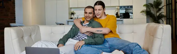 Una giovane coppia gay si rilassa su un divano bianco in un appartamento moderno, godendosi reciprocamente compagnia. — Foto stock