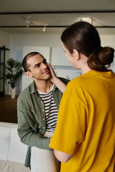 A young gay couple shares a tender moment in a modern apartment. — Stock Photo
