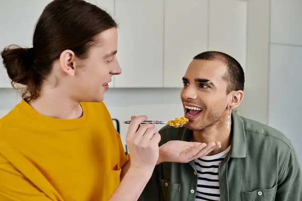 A young gay couple enjoys a light breakfast together in their modern apartment. — Stock Photo