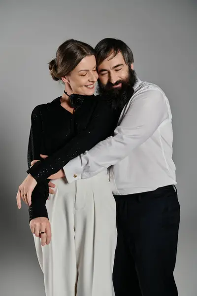 Um casal de roupas elegantes posar para uma foto, abraçando um ao outro com calor e carinho. — Fotografia de Stock