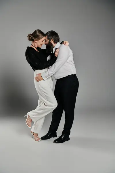 A loving couple in elegant attire poses for a portrait in a studio setting. — Stock Photo