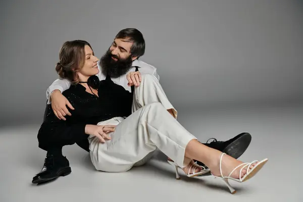 A loving couple, dressed in sophisticated attire, share a tender moment together in a studio setting. — Stock Photo