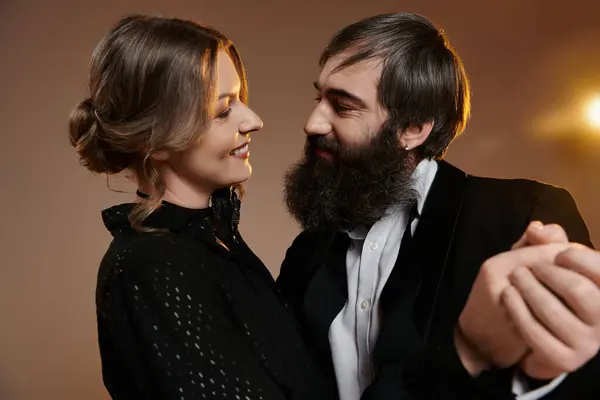 Ein Mann und eine Frau in eleganter Kleidung blicken einander liebevoll an. — Stockfoto