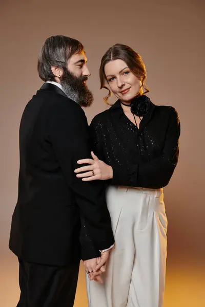 Un uomo e una donna in abito formale abbracciano, irradiando amore e raffinatezza. — Foto stock