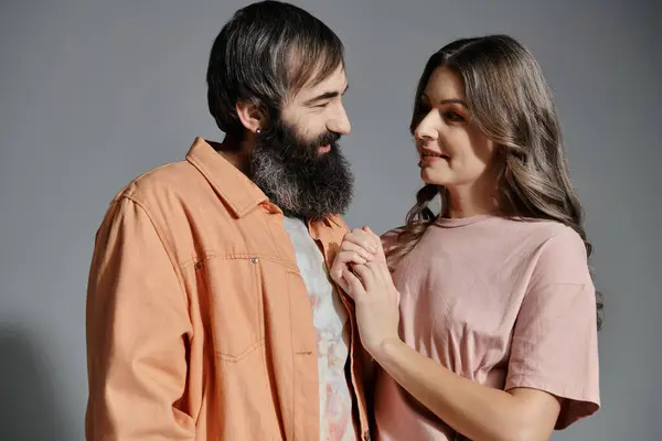 Um homem e uma mulher estão juntos, olhando nos olhos um do outro, num estúdio. — Fotografia de Stock