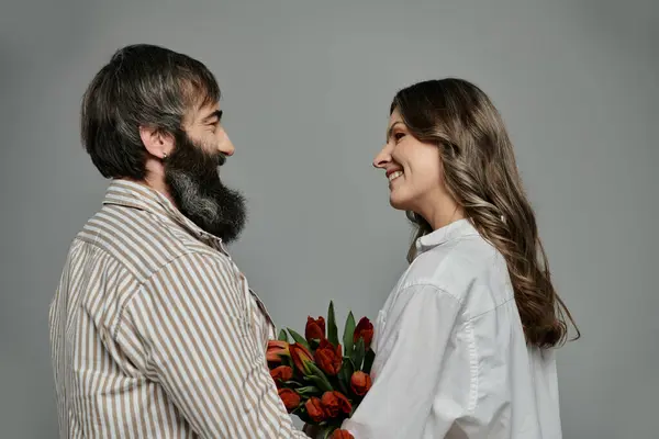 A man and woman in elegant clothing gaze lovingly at each other, capturing a tender moment. — Stock Photo
