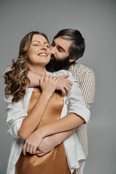A couple in elegant attire embraces each other in a studio setting. — Stock Photo