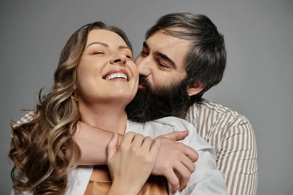 Um casal amoroso posa para um retrato, o homem abraçando a mulher enquanto ri. — Fotografia de Stock