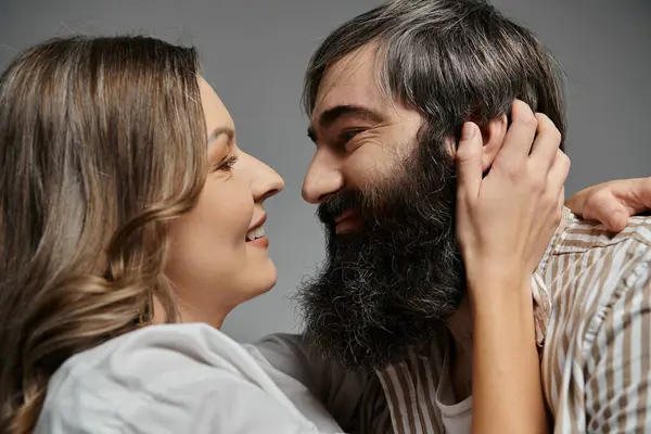 A couple in elegant attire, with a focus on their loving expressions, sharing a tender moment. — Stock Photo