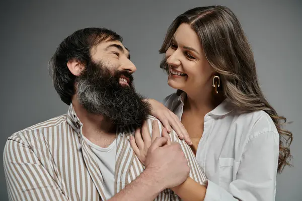 A couple in sophisticated attire poses together, laughing and gazing into each others eyes. — Stock Photo