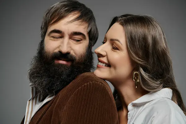 Ein verliebtes Paar in eleganter Kleidung posiert zusammen, die Frau flüstert dem Mann ein Geheimnis ins Ohr. — Stockfoto