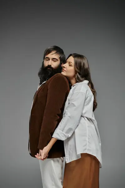 A loving couple dressed in stylish attire, posing with their arms around each other. — Stock Photo