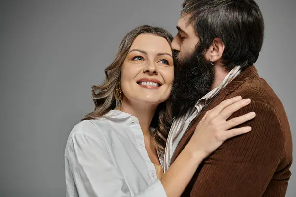 A loving couple poses together, the man gently kissing the womans forehead. — Stock Photo