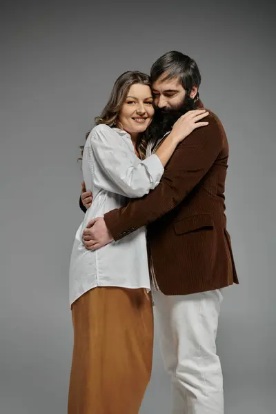 A couple in sophisticated attire embraces in a studio setting. — Stock Photo