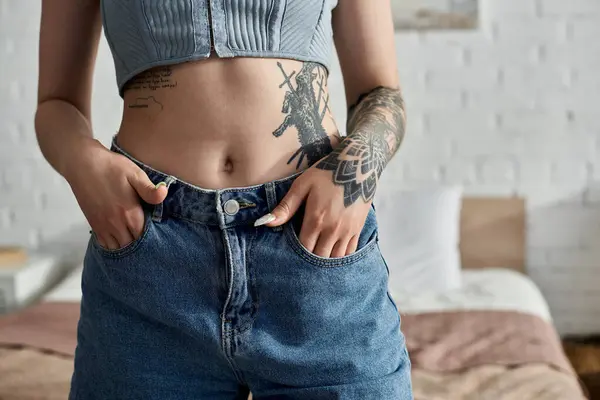 Uma jovem com tatuagens fica em seu apartamento, mãos nos bolsos, desfrutando de um fim de semana aconchegante.. — Fotografia de Stock