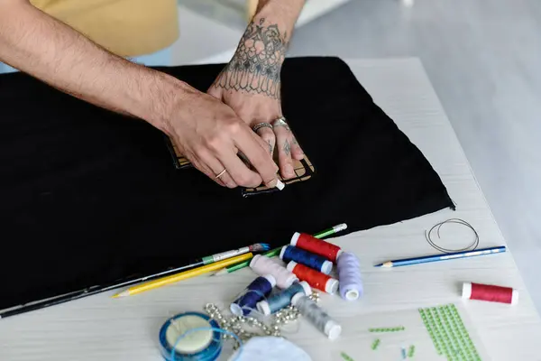 A young man traces a pattern onto fabric with chalk, preparing to breathe new life into discarded clothing at his sustainable atelier. — Stock Photo