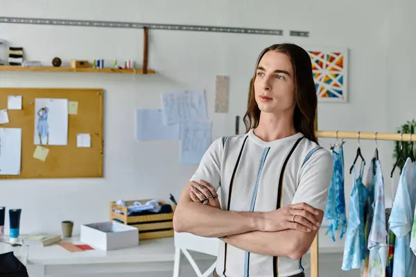 A young man stands confidently in his DIY clothing restoration atelier, showcasing his commitment to sustainable fashion. — Stock Photo