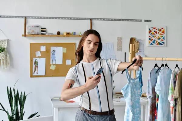 A young man examines a garment in his DIY clothing restoration atelier, where he breathes new life into discarded clothes, promoting sustainability and mindful fashion. — Stock Photo