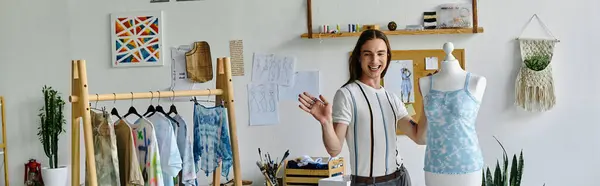A young man stands in his DIY clothing restoration atelier, surrounded by his work. He is passionate about giving new life to old items and promoting sustainable fashion. — Stock Photo