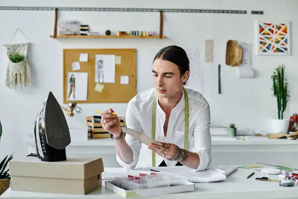 A young man meticulously examines a piece of fabric, ready to transform it into something new at his sustainable clothing restoration atelier. — Stock Photo