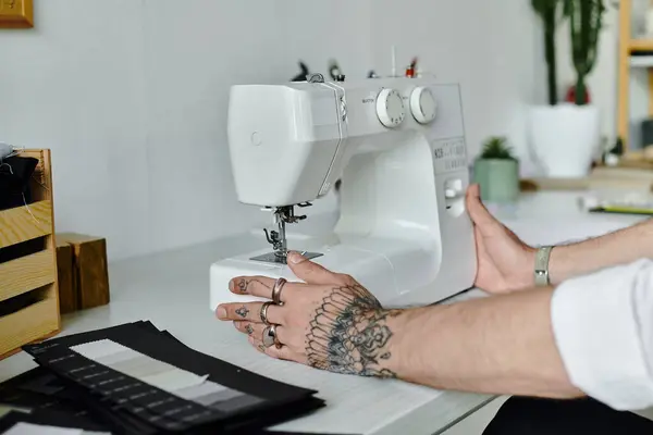 Tailor carefully adjusts a sewing machine in his atelier, transforming old clothes into something new. — Stock Photo