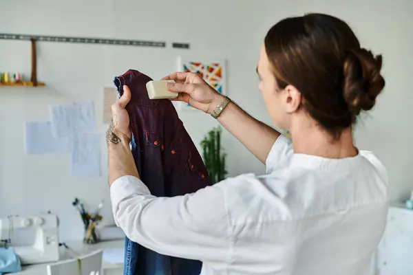 A young man meticulously applies soap to a garment in his DIY clothing restoration atelier, breathing new life into discarded clothes. — Stock Photo