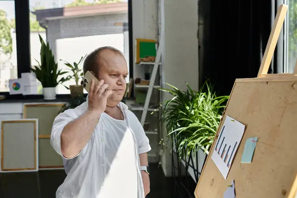 Um homem com inclusão em uma camisa branca fala em seu telefone em um escritório. — Fotografia de Stock