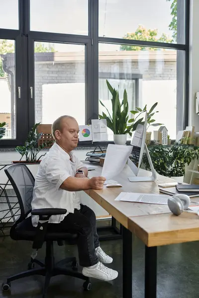 Un homme inclusif travaille à un bureau dans un bureau moderne. — Photo de stock