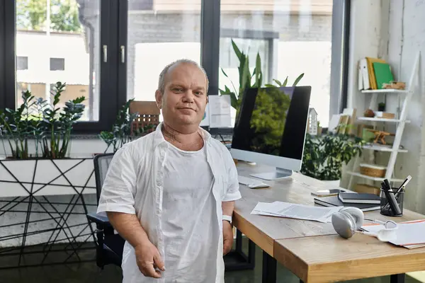 Un uomo con inclusività sta fiducioso nel suo ufficio, mostrando l'importanza della diversità e dell'inclusività sul posto di lavoro.. — Foto stock