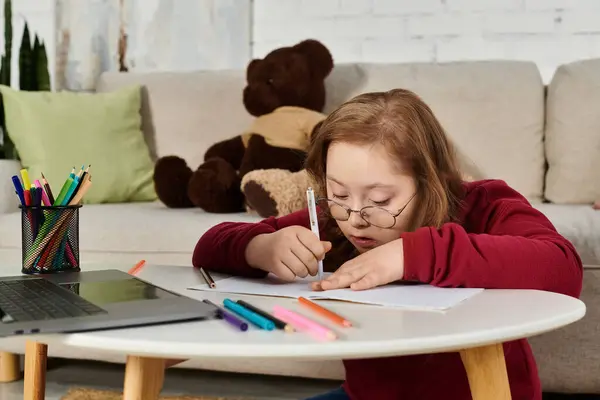 Bambina con sindrome di Down crea arte a casa con forniture colorate. — Foto stock