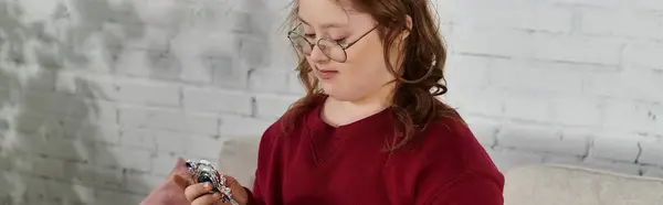 A little girl with Down syndrome examines toy magic wand in her home. — Stock Photo