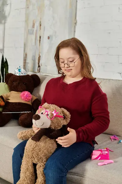 A little girl with Down syndrome plays with her teddy bear at home. — Stock Photo