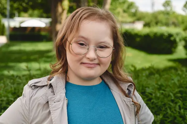 A little girl with Down syndrome smiles brightly while spending time outdoors. — Stock Photo