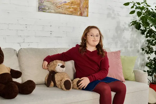 A little girl with Down syndrome enjoys a day at home, surrounded by her favorite toy animals. — Stock Photo