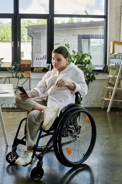 A young businesswoman with a disability is sitting in a wheelchair and working in a modern office. — Stock Photo