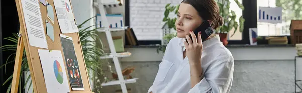 Молодая предпринимательница в инвалидной коляске работает в современном офисе, демонстрируя инклюзивность на рабочем месте. — стоковое фото