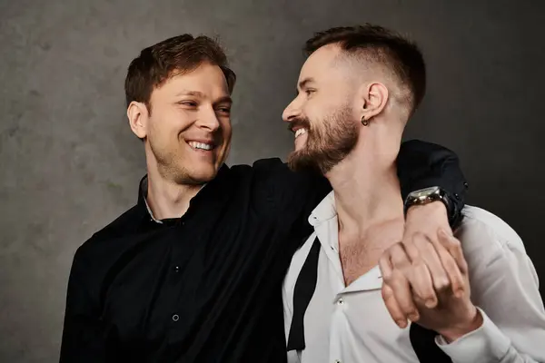 A portrait of two men in suits, smiling and looking at each other lovingly. — Stock Photo