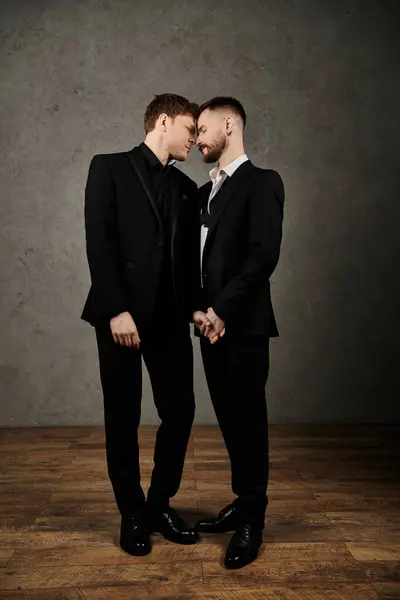 Two men in elegant suits stand close, foreheads touching, in a tender moment of love. — Stock Photo