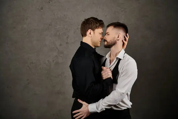 Ein schwules Paar in eleganten Anzügen steht dicht beieinander und teilt einen zärtlichen Moment. — Stockfoto