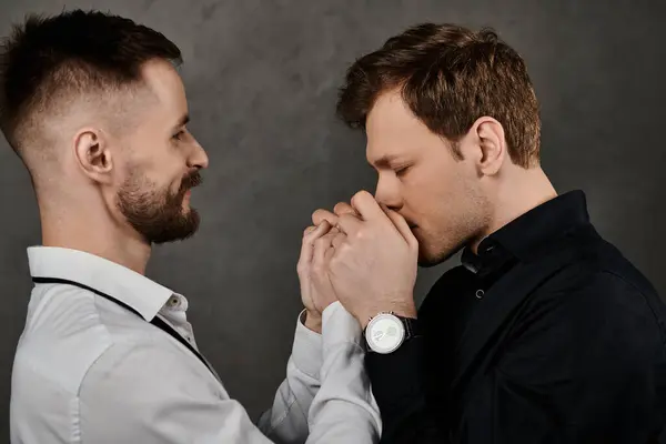 Due uomini in abiti eleganti condividono un momento d'amore, si tengono per mano e si guardano. — Foto stock